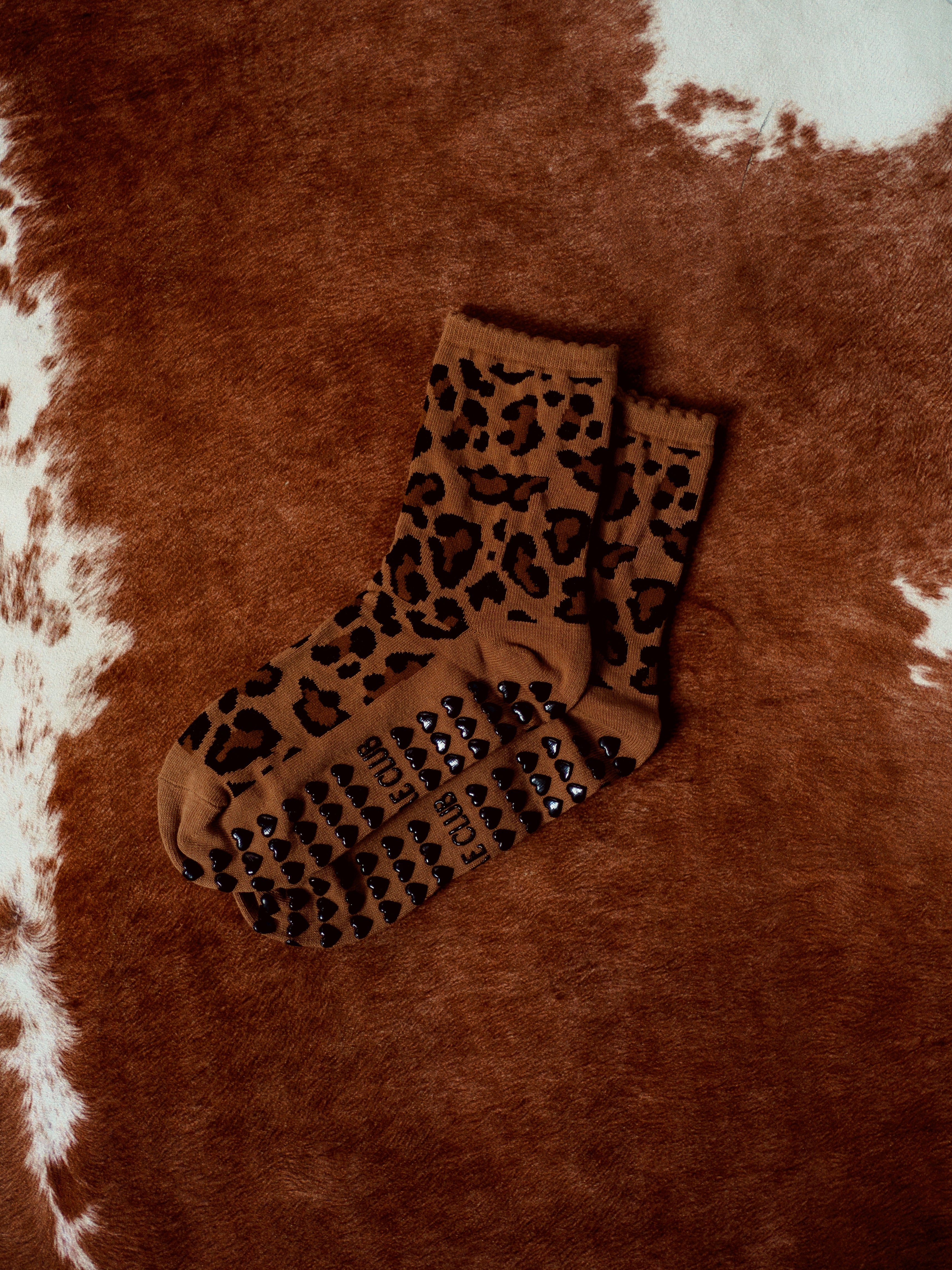 TCC Cheetah Print Grip Socks – bold cheetah pattern with black heart grippies. One-size-fits-all Pilates socks, perfect for Pilates, barre & yoga.