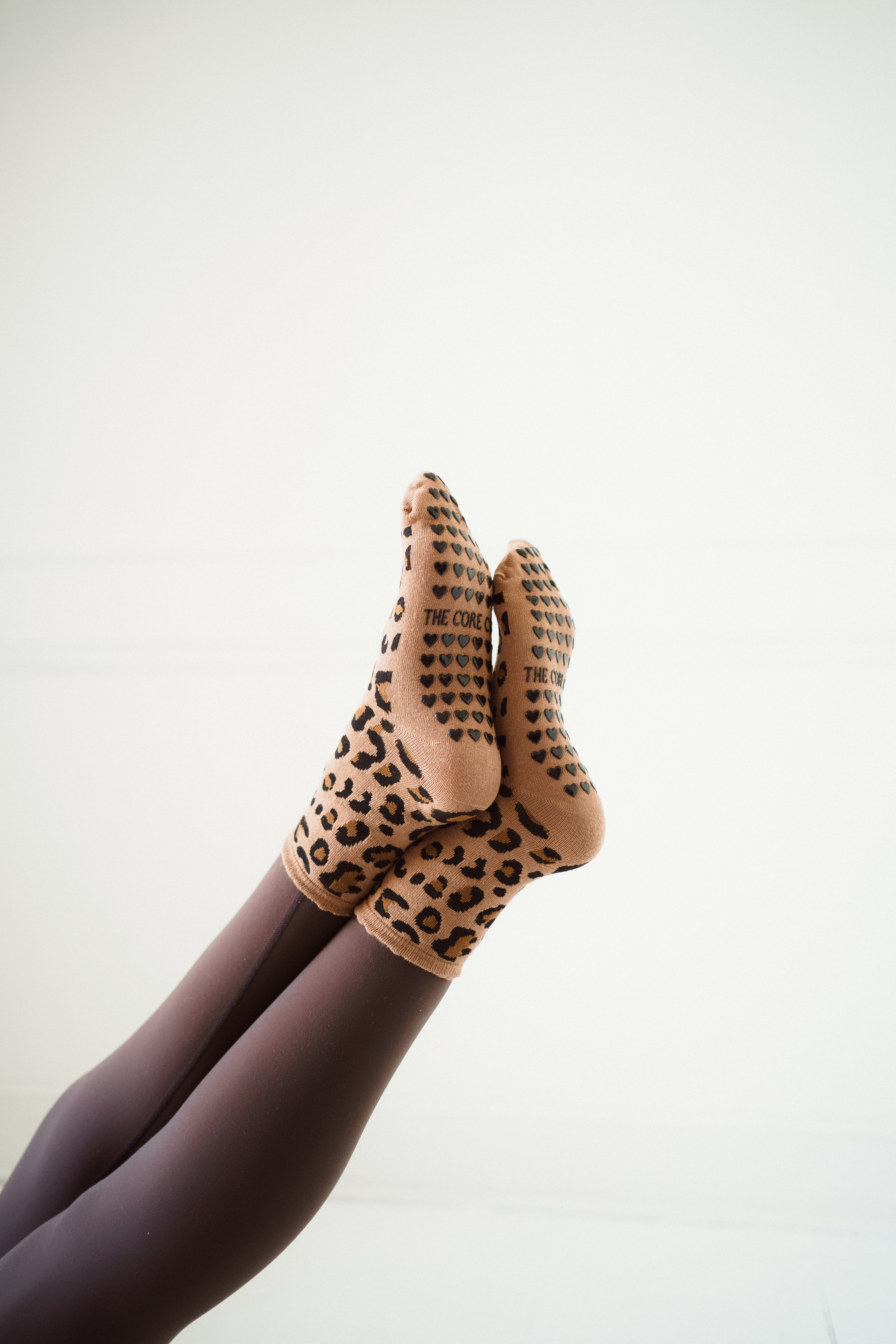 TCC Cheetah Print Grip Socks – bold cheetah pattern with black heart grippies. One-size-fits-all Pilates socks, perfect for Pilates, barre & yoga.