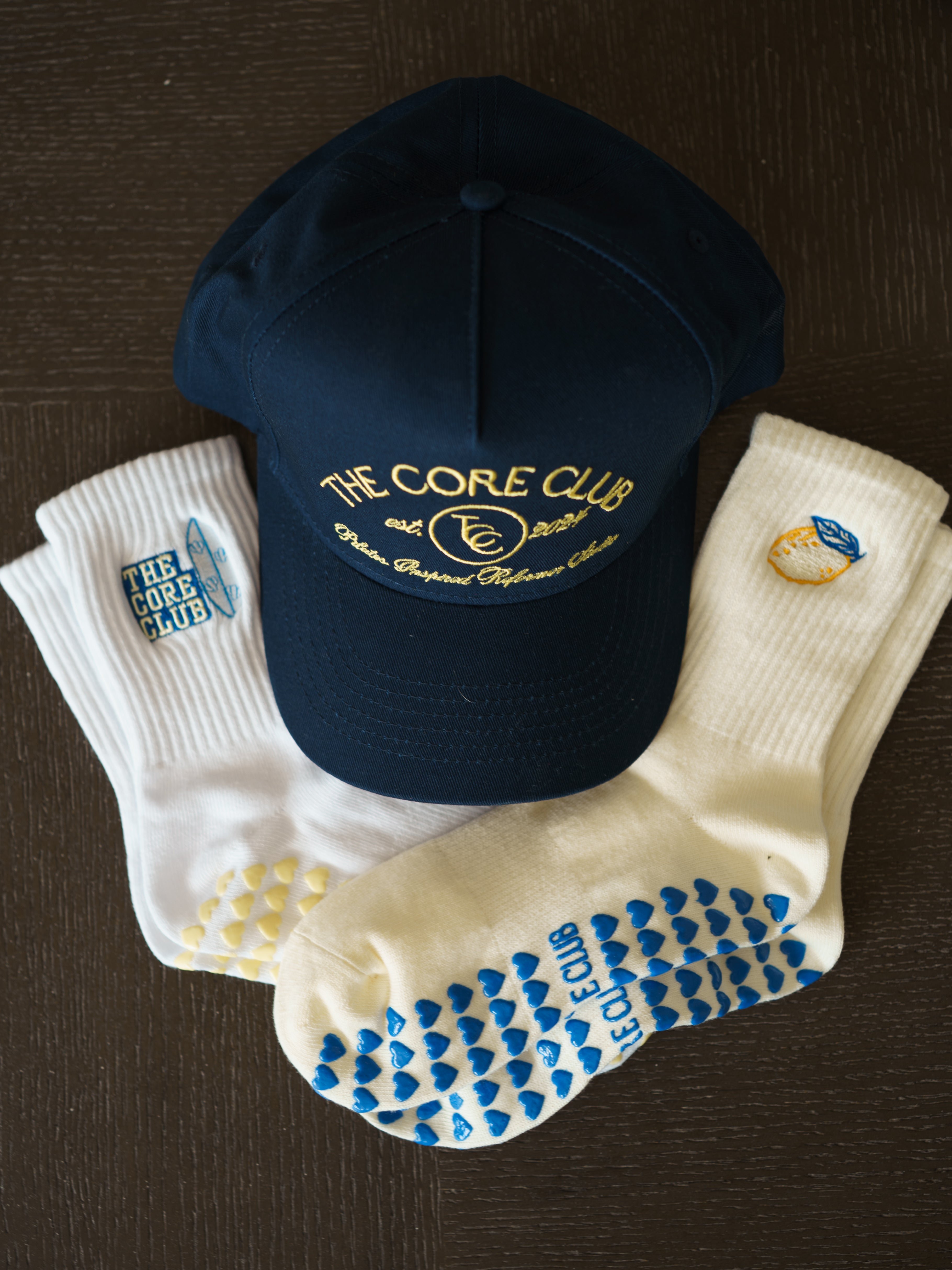 Core Club TCC Coastal Pilates grip socks and navy and yellow baseball hat 