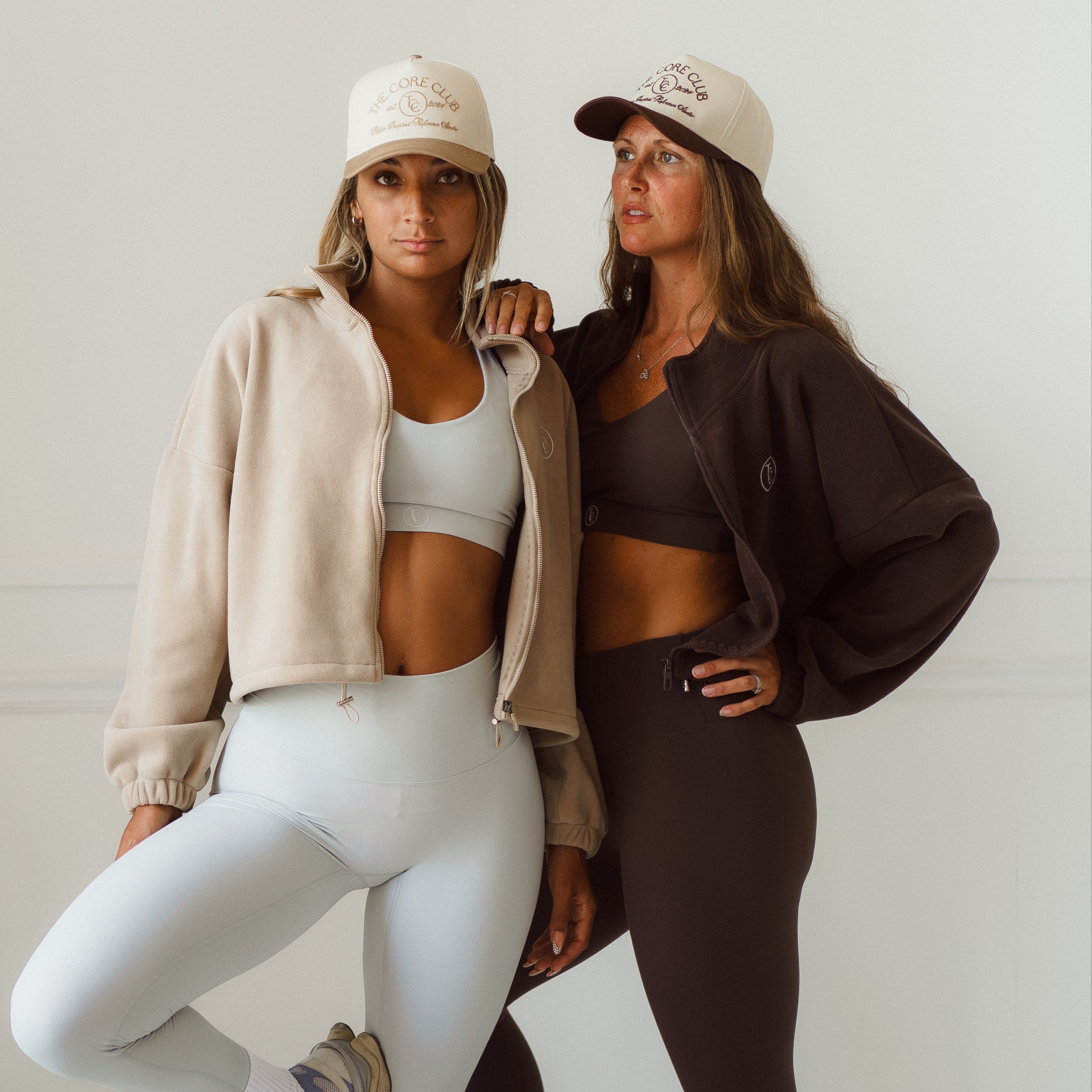core club pilates instructors posing in core club TCC pilates sets activewear with jackets and baseball hats, neutral aesthetic