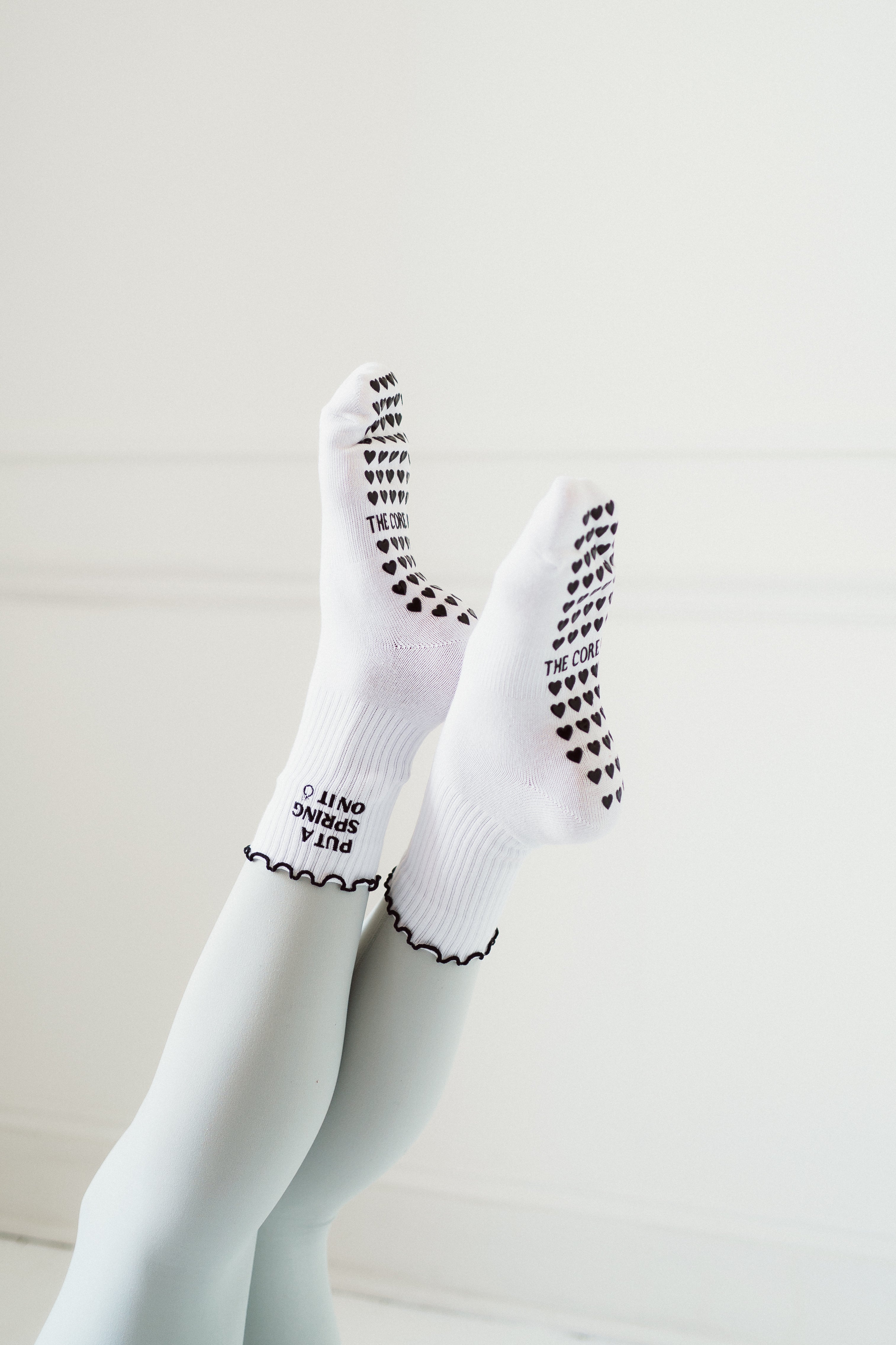 TCC Put a Spring on It pilates grip socks with black heart grips on bottom, ruffle top