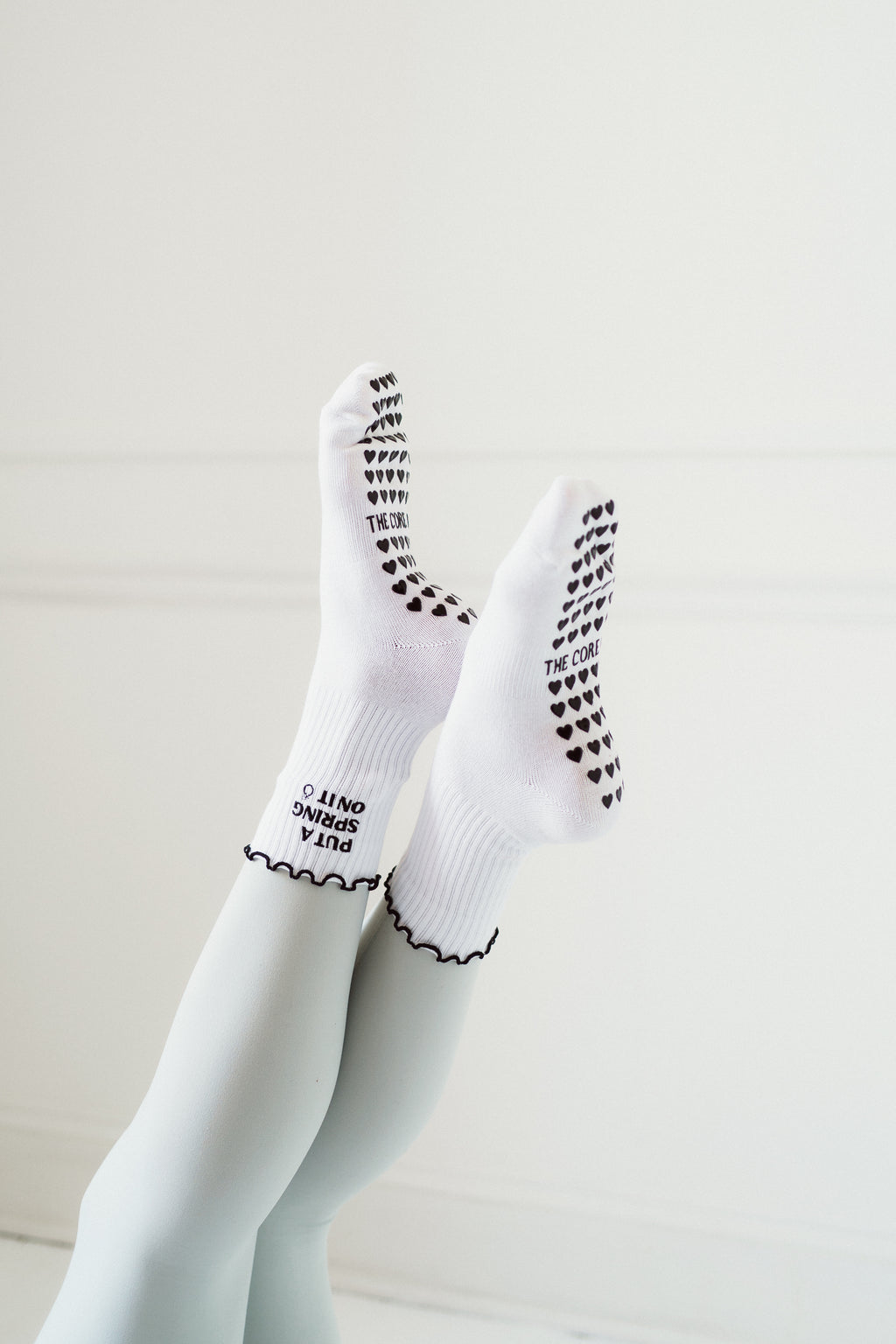 TCC Put a Spring on It pilates grip socks with black heart grips on bottom, ruffle top